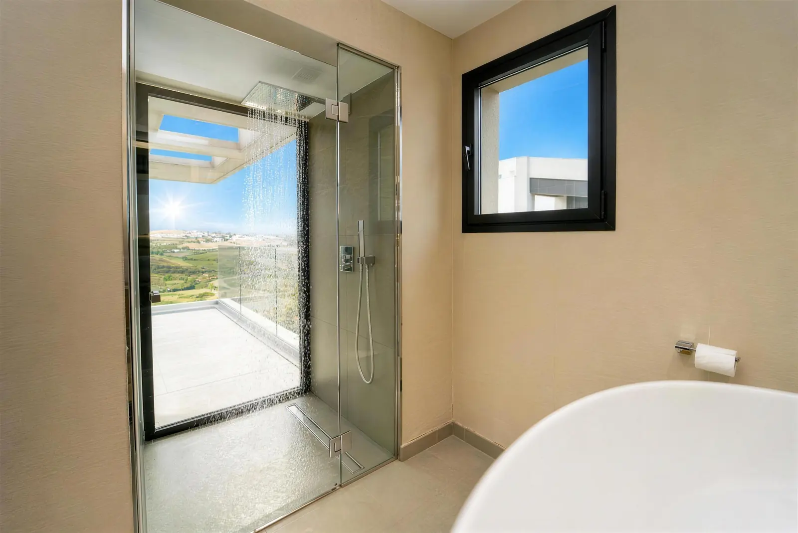 Hauptbad mit Regendusche am Fenster und freistehender Badewanne