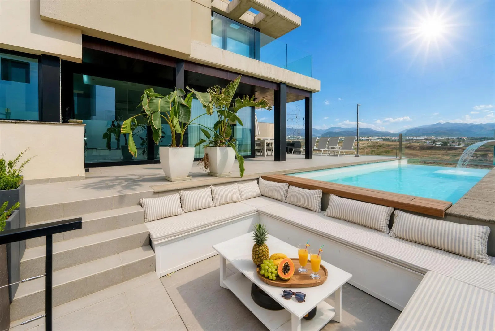 Lounge am Pool mit Bananenpflanzen in Kübeln und dem Haus dahinter