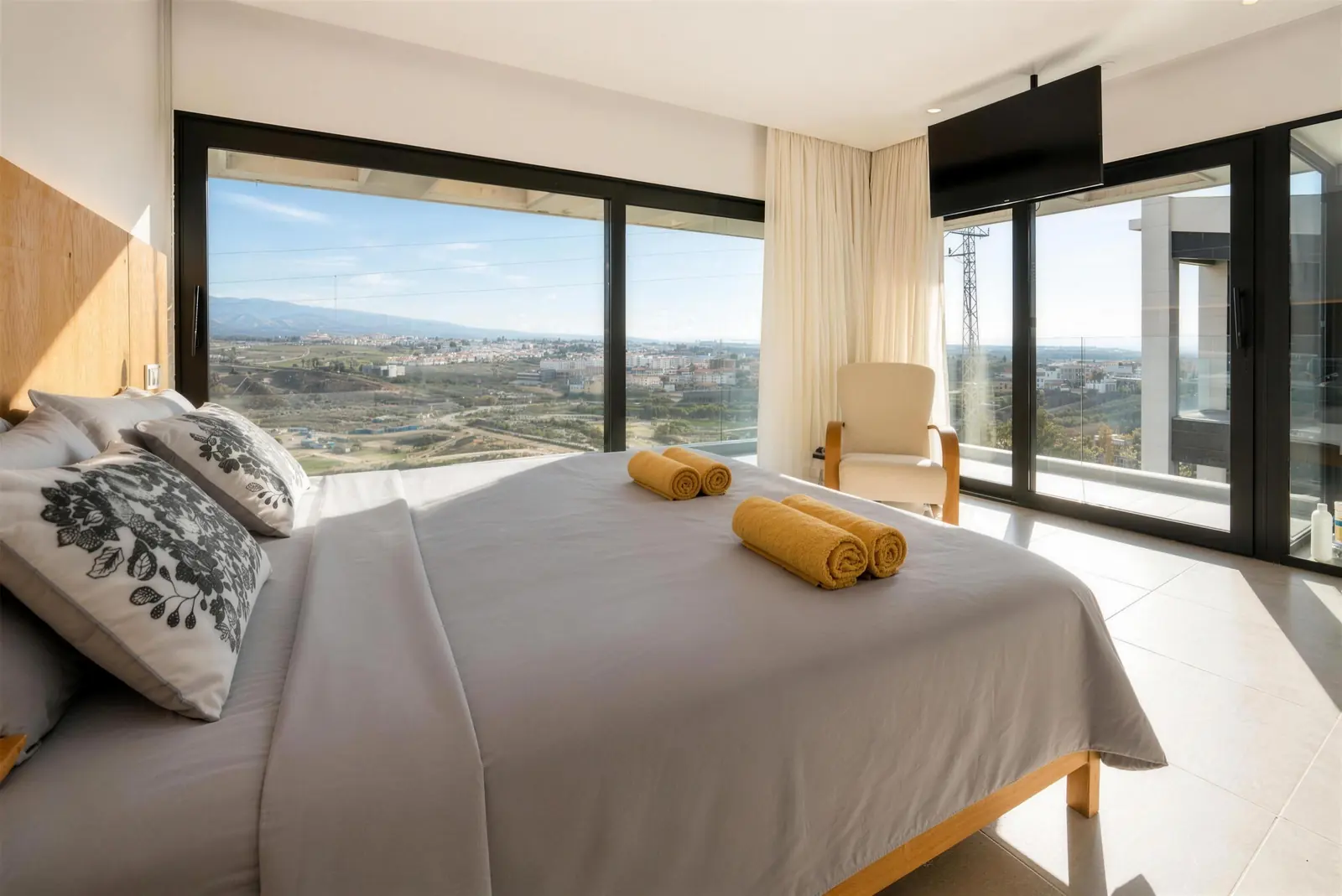 Dormitorio principal con ventanales de suelo a techo y vistas a la montaña