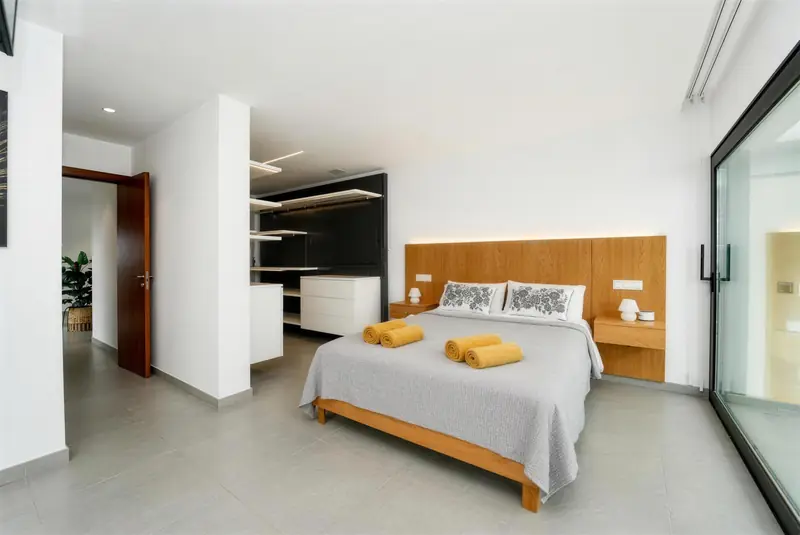 Dormitorio con cabecero de madera y vestidor abierto