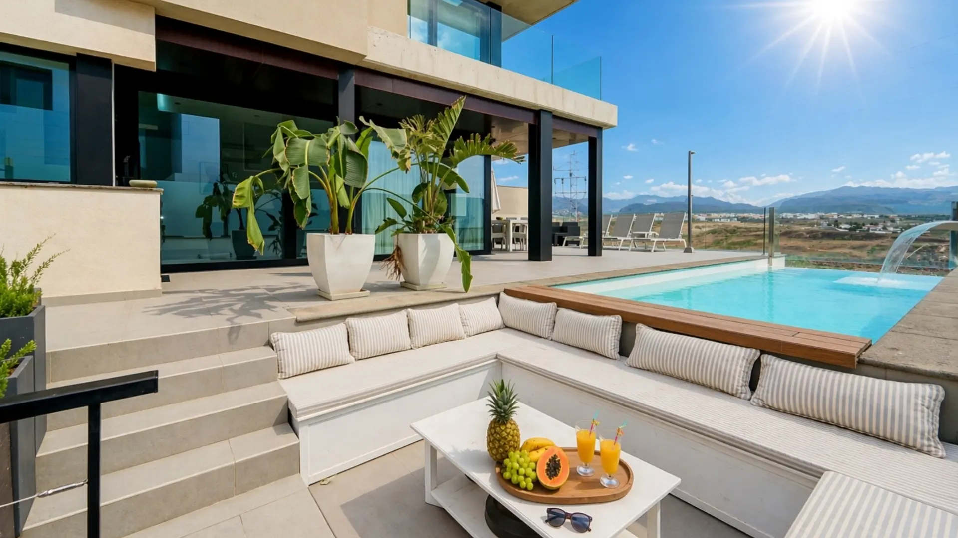 Lounge am Pool mit Bananenpflanzen in Kübeln und dem Haus dahinter